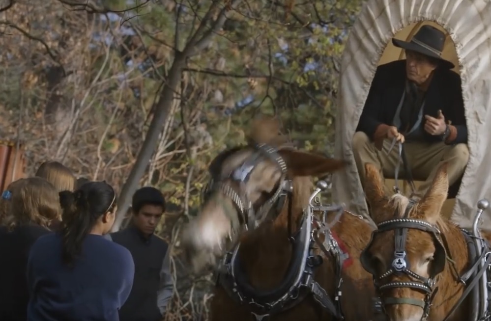 man in a wagon with people and a horse